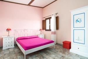 Dormitorio rosa con cama rosa y ventana en casa Stella, en Dorgali