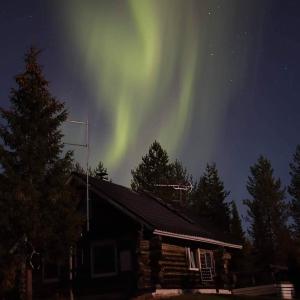 ein Bild der Aurora Borealis über einem Haus in der Unterkunft In Love with Lapland Cabin in Ranua