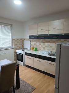 a kitchen with white cabinets and a stove top oven at 2BDR Apt with Balcony view - Free parking 2 in Sarajevo