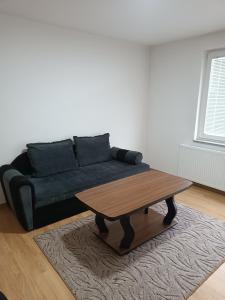 a living room with a couch and a coffee table at 2BDR Apt with Balcony view - Free parking 2 in Sarajevo