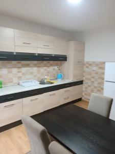 a kitchen with white cabinets and a table and chairs at 2BDR Apt with Balcony view - Free parking 2 in Sarajevo