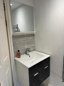 a bathroom with a white sink and a mirror at Russell square Apartment 4 city in Brighton & Hove