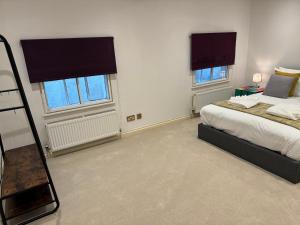 sypialnia z łóżkiem i 2 oknami w obiekcie Russell square Apartment 4 city w Brighton and Hove