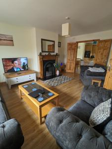 ein Wohnzimmer mit 2 Sofas und einem TV in der Unterkunft 4 Bed House, spacious & modern with parking Tubbercurry in Tobercurry