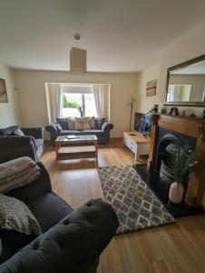 a living room with a couch and a fireplace at 4 Bed House, spacious & modern with parking Tubbercurry in Tobercurry