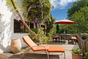 eine Terrasse mit Stühlen und einem Tisch mit einem Sonnenschirm in der Unterkunft Ferienhaus Auszeithaus 