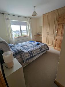 a bedroom with a bed and a window at 4 Bed House, spacious & modern with parking Tubbercurry in Tobercurry