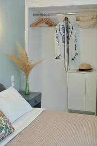 una camera con letto e camicia su una mensola di Greekowl apartments a Città di Skiathos