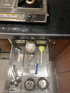 a metal strainer in a kitchen drawer with utensils at Luxurious 2BHK Flat/South Delhi/Prime Location in New Delhi