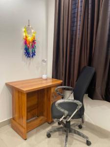 a desk and a chair next to a wooden table at Luxurious 2BHK Flat/South Delhi/Prime Location in New Delhi