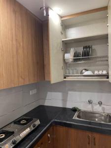 a kitchen with a sink and a stove and cabinets at Luxurious 2BHK Flat/South Delhi/Prime Location in New Delhi