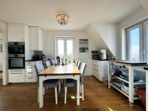 - une cuisine avec une table et des chaises en bois dans l'établissement Lovely apartment with sea view on Hono, à Hönö