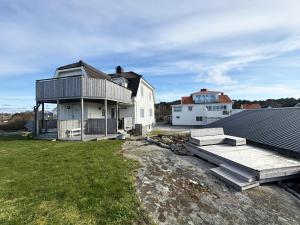 une grande maison avec une terrasse et une maison dans l'établissement Lovely apartment with sea view on Hono, à Hönö