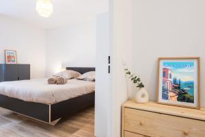 1 dormitorio con cama y tocador de madera en BOUIN - Frontière Monaco - Luxueux 2 pièces refait à neuf en Beausoleil