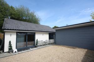 a detached house with a garage and chairs at Ferndown Holiday Let in Ferndown