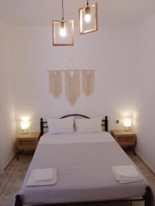a bedroom with a large bed with two night stands at Meltemi Rooms and Studios in Anafi