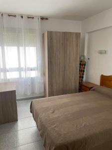 1 dormitorio con 1 cama y armario de madera en CN Rents, en Peñíscola