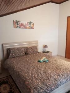 a bed with a pair of shoes sitting on it at S.T Family Apartement in Kalabaka