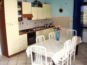 eine Küche mit einem Tisch mit Stühlen und einer Vase aus Blumen in der Unterkunft One bedroom house with sea view and enclosed garden at Casal Velino 6 km away from the beach in Casal Velino