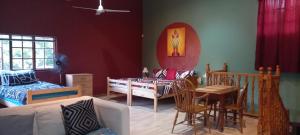 a living room with a bed and a dining room at Thrush Nest Durban in Pinetown