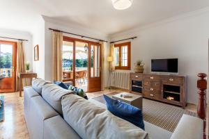 a living room with a couch and a tv at Sa Trona Beach House in Cala Santanyi