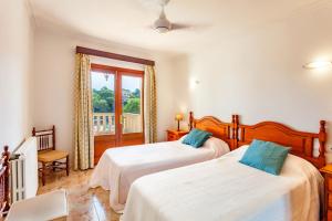1 dormitorio con 2 camas y balcón en Sa Trona Beach House, en Cala Santanyi