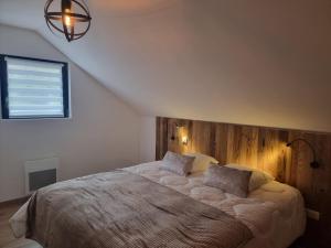 - une chambre avec un grand lit et une tête de lit en bois dans l'établissement Le Chalet de Maeva * 10 pers * jacuzzi, à Xonrupt-Longemer