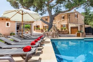 a row of chaise lounge chairs next to a swimming pool at Ses Angoixes in Santanyi