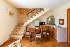 cocina y comedor con escalera y mesa en Ses Angoixes, en Santanyí