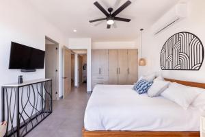 una camera con letto bianco e ventilatore a soffitto di Modern Beachfront Residence with Resort Amenities a El Pescadero Altre 47 foto