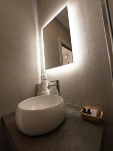 lavabo blanco en el baño con espejo en Albergo Deva, en Riva del Garda