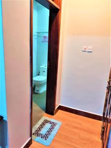 łazienka z toaletą i drzwiami z dywanem w obiekcie Ryker's Place w mieście Kampala