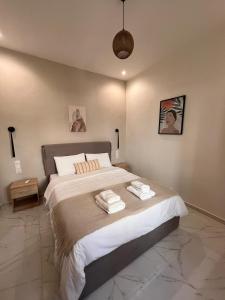 een slaapkamer met een groot bed en 2 handdoeken bij Modh Patras City Centre - Entire flat in Patra
