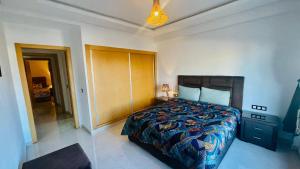 a bedroom with a bed and a dresser in it at Essaouira Beach Design Apartment in Essaouira