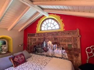 QuelfesにあるCasa Stardust & cottagesの赤い壁のベッドルーム1室(窓付)