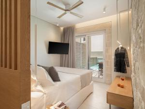 a bedroom with a bed with a ceiling fan at Pietra Di Sabbia Villas in Palaiochora