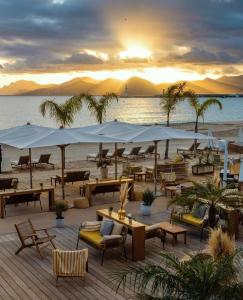 a beach with tables and umbrellas on a beach at Five Seas by Inwood Hotels in Cannes