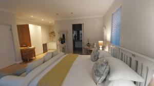 a bedroom with a large white bed and a couch at Knysna Private Estate Lagoon Apartment - Garden Apartment - Secure Estate in Knysna