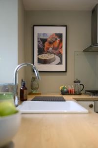um balcão de cozinha com um lavatório e uma imagem na parede em The Beeches - Chatsworth Apartment No 3 - Sleeps 2 em Baslow
