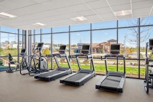 een fitnessruimte met een rij loopbanden en crosstrainers bij SpringHill Suites by Marriott Menomonee Falls in Menomonee Falls