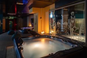 uma banheira de hidromassagem num quarto com um quarto em Aria Life Hotel em Limone sul Garda