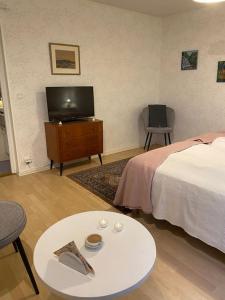 een slaapkamer met een bed en een tafel en een televisie bij Lantgård nära stad, fiske o golf in Malmö