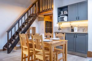 een keuken en eetkamer met een houten tafel en stoelen bij Skyhook: Batiment B in Chamonix-Mont-Blanc
