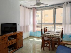 a dining room with a table and a television at Apartamento Gandia Bellreguard 3000 in Bellreguart