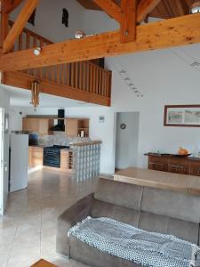 a living room with a couch and a kitchen at Maison sanguinet à 100m du lac in Sanguinet