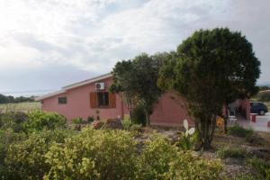 een roze huis met bomen ervoor bij VILLA CATERINA in Calasetta