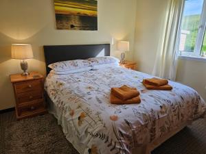 1 dormitorio con 1 cama con 2 toallas en Ash Cottage en Stranraer