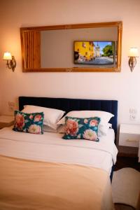 a bedroom with a bed with two pillows and a mirror at Joseph Hayn Apartments in Sighişoara