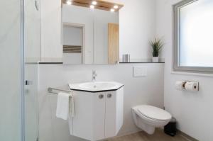 a white bathroom with a toilet and a sink at Ferienwohnungen Walz in Pfullendorf