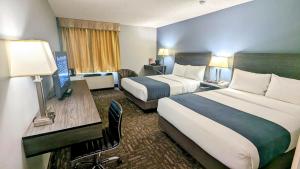 a hotel room with two beds and a desk at Crestwood Hotel in Hinton